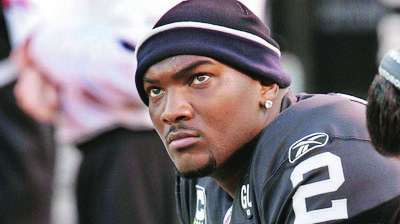 FILE - In this Nov. 30, 2008, file photo, Oakland Raiders quarterback JaMarcus Russell sits on the bench during an NFL football game against the Kansas City Chiefs in Oakland, Calif. The Raiders released former No. 1 overall pick Russell on Thursday, May 6, 2010, ending a three-year tenure marked by his high salary and unproductive play on the field. (AP Photo/Paul Sakuma, file)