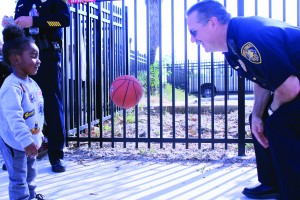 Drae Cavaness (3) grandson of Dewboy Lister Sr. plays a little basketball with Officer Ed Shannon during the peaceful gathering on October 22, 2017.
