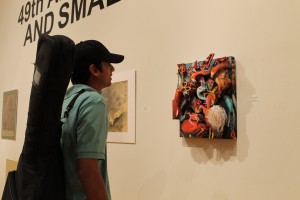 Texas A&M kingsville student Satyajith Akkinpally admires the art displayed at the art show on Feb 20. 