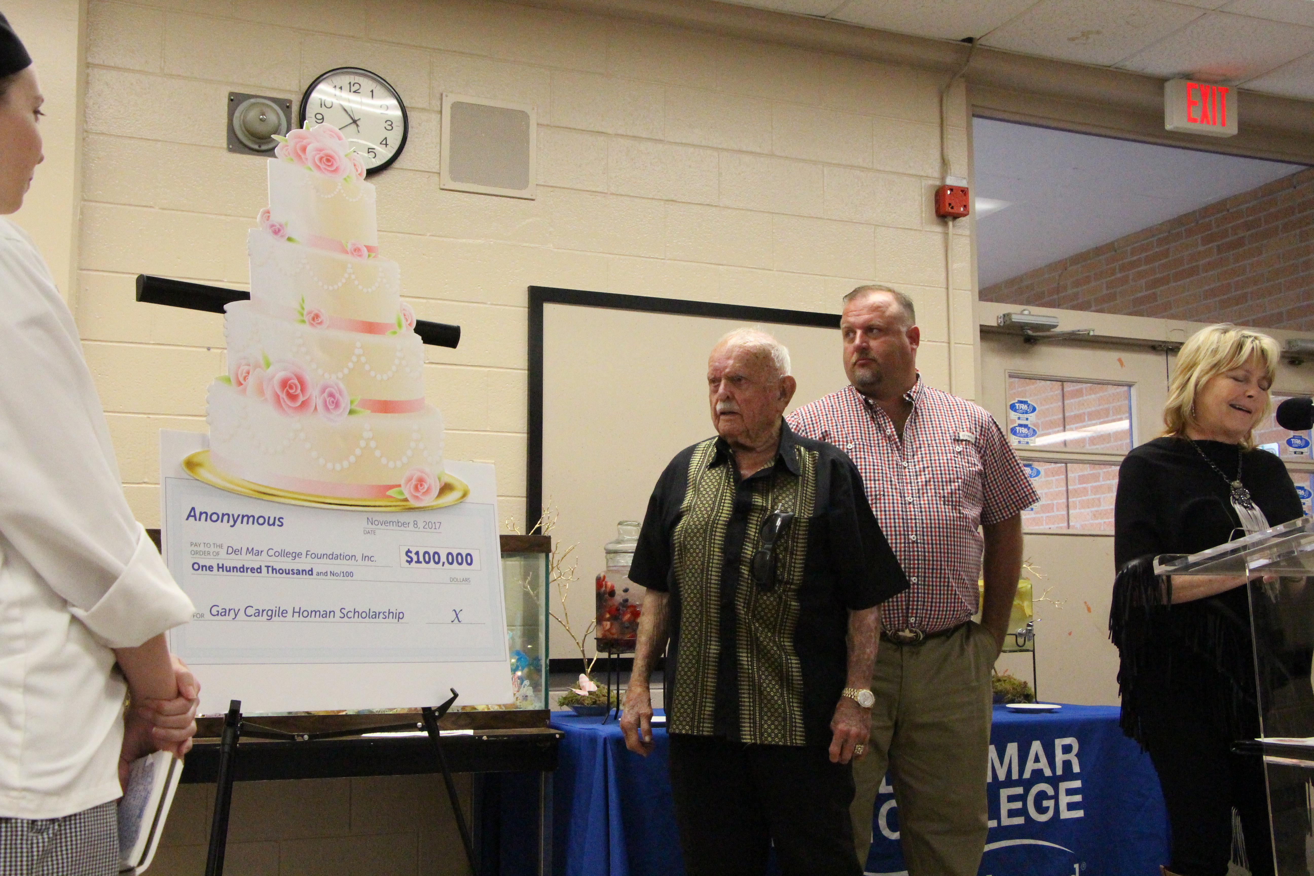 Gus Cargile (from left) and his grandson, Mike Homan, look on as Mary McQueen, with the DMC Foundation, announces a $100,000 donation made in honor of Gus' daughter and Mike's Mom, Gary Homan, on Nov. 15 at West Campus.