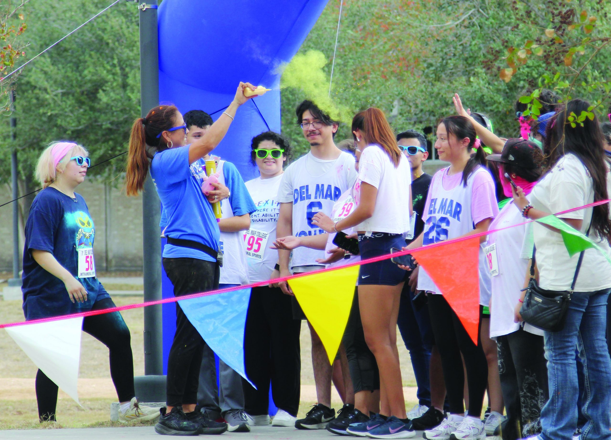 Intramural Director Carla Gamez Vela Squirts Different Colored Dyes Into The Crowd To Prepare Students For The Color Run On Wednesday Nov. 19. Students Ran Or Walked Two Laps Around The Heritage Campus While Listening To Music And Were Greeted With Medals, Shirts, And Snacks At The Finish Line.