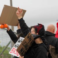 Dilley Detention protestor stands outside facility on April 18th demanding accountibility for unlivable conditions.