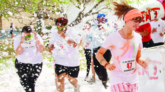 Students running in the color run through the foam gun at Del Mar College Heritage campus. Photo by Victor Herrera